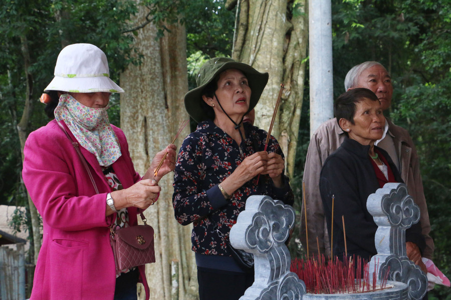 Bà Bền (ở giữa) đang thắp hương tưởng nhớ về những người anh, những đồng chí, đồng đội của mình đã nằm xuống nơi đây trong những năm chiến đấu ác liệt. Ảnh: Q.T