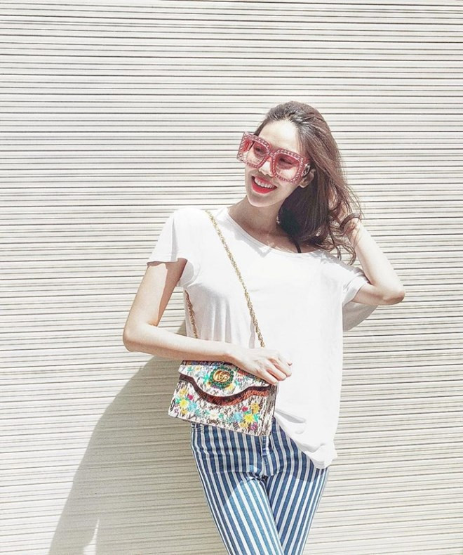  Diện áo thun trắng và quần kẻ sọc đơn giản, Lan Khuê nâng tầm bộ cánh street style bằng cặp phụ kiện kính mắt bản to cùng túi xách ''cộp mác'' Gucci.