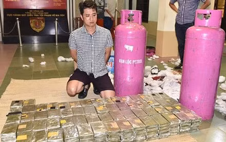 Đối tượng và hàng trăm bánh heroin tang vật trong đường dây ma tuý xuyên quốc gia.