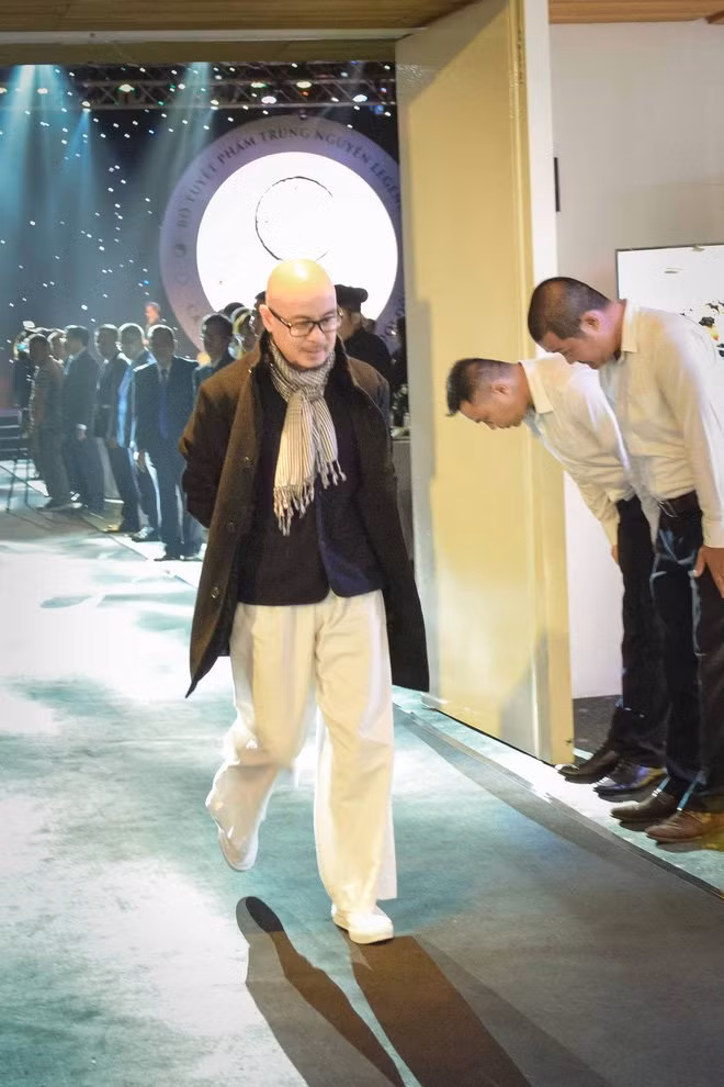 Ở lối đi chính xuất hiện hàng chục nam nhân viên áo vest đen, sơ mi trắng sắp thành hai hàng, cúi rạp người đón ông (theo Nhịp sống Kinh tế). Ở lối đi chính xuất hiện hàng chục nam nhân viên áo vest đen, sơ mi trắng sắp thành hai hàng, cúi rạp người đón ông (theo Nhịp sống Kinh tế).