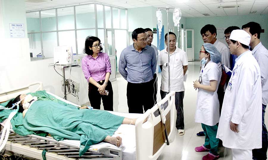 Ông Khuất Việt Hùng (người đứng thứ 2 từ trái sang) đếm thăm hỏi, động viên các nạn nhân bị thương trong vụ tai nạn. Ảnh: Sơn Tùng