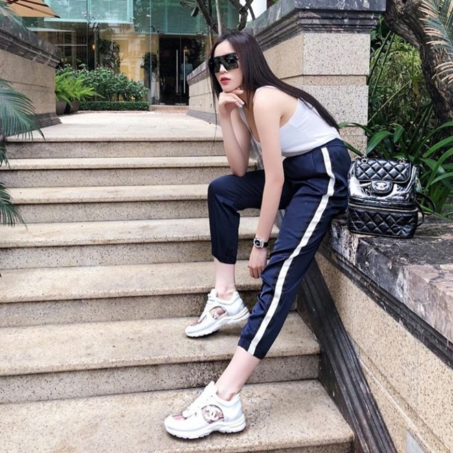 Ghép đôi áo tank trắng và quần kẻ sọc bên hông, Kỳ Duyên hoàn thiện phong cách thể thao bằng đôi sneakers ''hầm hố'' của Chanel, không quên xách theo chiếc balô phối chất liệu trong suốt yêu thích cùng thương hiệu.