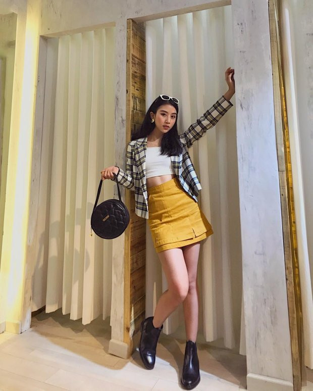  Ở một set đồ khác, Quỳnh Anh khéo léo kết hợp túi và boot màu đen cùng áo khoác sọc đen trắng để cân bằng sự nổi bật của tông vàng.