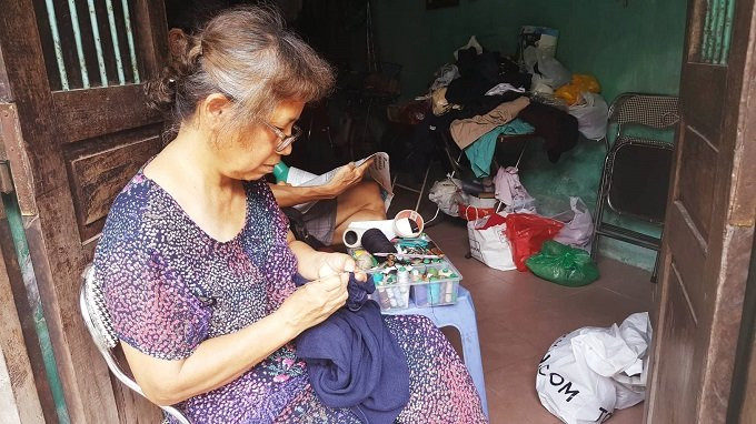 Bà Hồng đang mạng lại chiếc áo len cho khách hàng. 