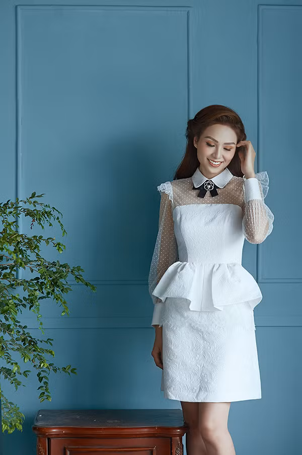 Trang phục cho các bạn gái yêu phong cách tiểu thư với phom dáng váy peplum được thêm các điểm nhấn như xếp bèo nhún, tay bồng nhẹ nhàng đi kèm kiểu nơ cài hoa tông màu tương phản.