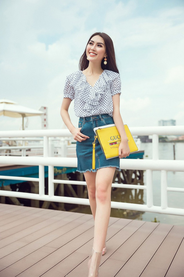 Phong cách trẻ trung cho nàng công sở sành điệu với áo bèo nhún đi cùng chân váy jean, clutch tông màu nổi và bốt nhựa trong.