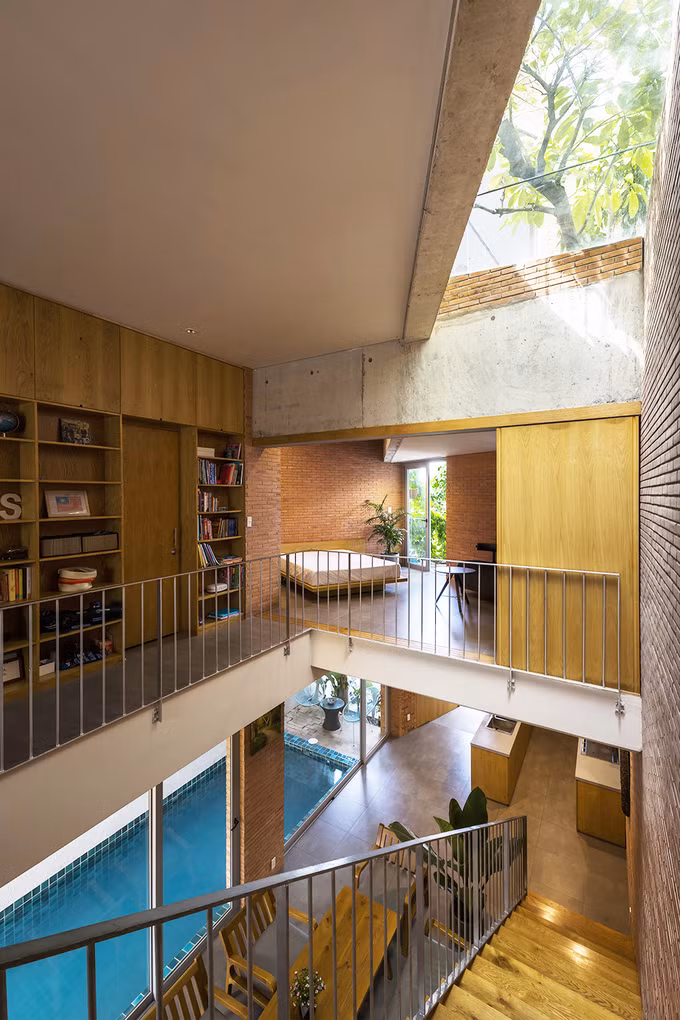 Nhà được thiết kế dạng ống nhưng các khoảng lệch tầng, đặc biệt là hành lang kiêm giếng trời khiến ngôi nhà luôn ngập tràn ánh sáng. Không gian giữa tầng trệt và tầng một theo kết cấu mở, để các thành viên trong gia đình dễ dàng kết nối với nhau hơn.