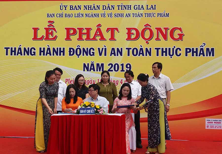  Đại diện Ban chỉ đạo liên ngành về vệ sinh ATTP tỉnh và đại diện cơ sở sản xuất, kinh doanh ký cam kết trong công tác đảm bảo ATTP. Ảnh: N.N