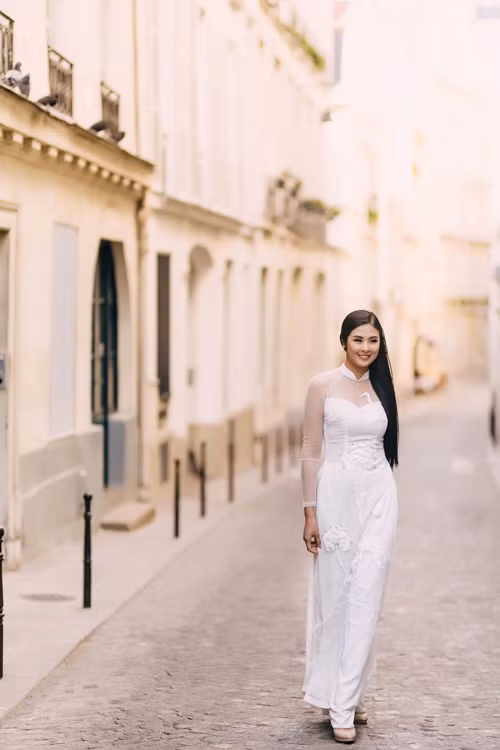  Thiết kế cổ hai trong một thể hiện việc bắt kịp xu hướng thời trang cưới hiện đại của NTK. Lớp vải voan xuyên thấu ở cổ, tay áo gợi vẻ quyến rũ của tân nương mà không làm mất đi sự duyên dáng. 