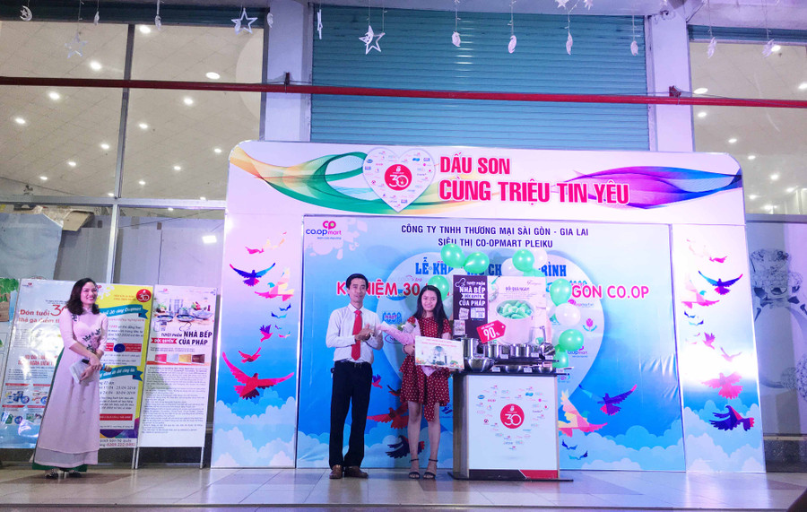 Ông Bùi Quốc Bình-Giám đốc siêu thị Co.opmart trao giải cho khách hàng may mắn tham gia chương trình tích tem đổi quà. Ảnh: Vũ Thảo