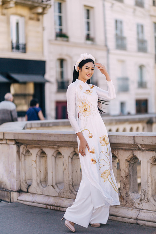 NTK - Hoa hậu Ngọc Hân sắp xếp họa tiết sen trải dài dọc thân theo đường chữ S giúp cô dâu trở nên cao ráo, nhấn vòng eo thon. NTK - Hoa hậu Ngọc Hân sắp xếp họa tiết sen trải dài dọc thân theo đường chữ S giúp cô dâu trở nên cao ráo, nhấn vòng eo thon.