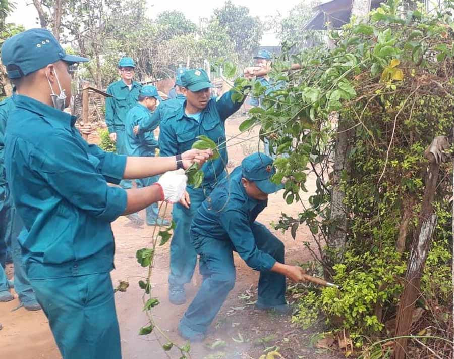 Lực lượng dân quân tự vệ giúp dân làng Nhao 2 dọn vệ sinh đường giao thông. Ảnh: N.T