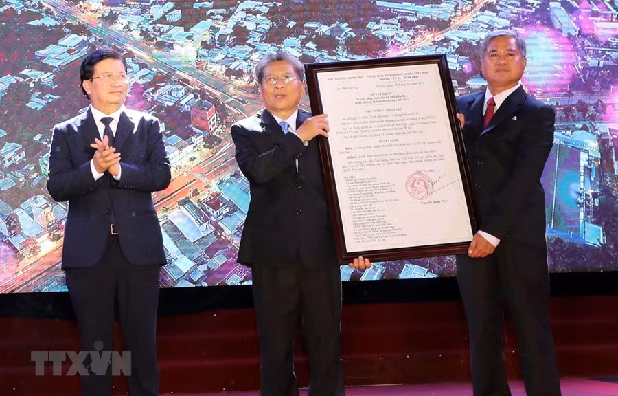  Phó Thủ tướng Trịnh Đình Dũng trao Quyết định của Thủ tướng Chính phủ công nhận thành phố Bến Tre là đô thị loại II trực thuộc tỉnh Bến Tre. (Ảnh: Trọng Đức/TTXVN)