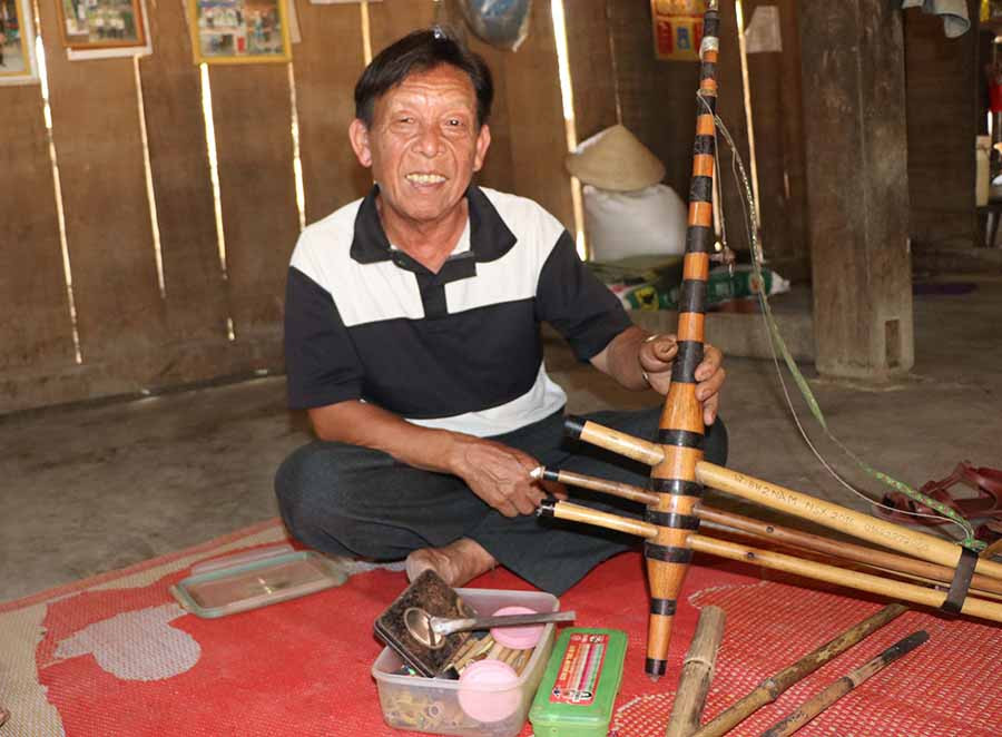  Ông Tính bên cây khèn quý và hộp dụng cụ chế tác nhạc cụ. Ảnh: N.M