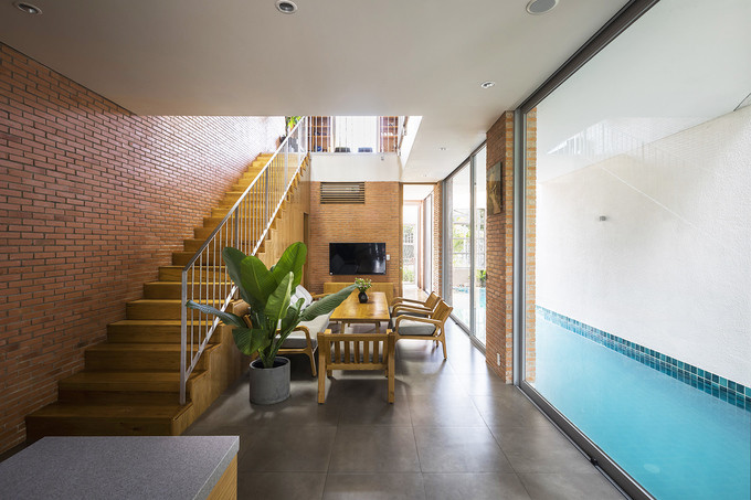 Không gian hẹp bề ngang nhưng các KTS đã thiết kế đáp ứng yêu cầu của gia chủ là có một bể bơi lớn, cùng với không gian để tập thể dục, phòng ngủ cho bà ngoại, phòng khách và phòng ăn, bãi đậu xe, tất cả đều ở tầng trệt. Không gian hẹp bề ngang nhưng các KTS đã thiết kế đáp ứng yêu cầu của gia chủ là có một bể bơi lớn, cùng với không gian để tập thể dục, phòng ngủ cho bà ngoại, phòng khách và phòng ăn, bãi đậu xe, tất cả đều ở tầng trệt.