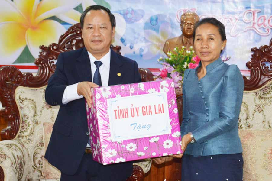 Phó Bí thư Tỉnh ủy Châu Ngọc Tuấn (bìa trái) tặng quà cho lãnh đạo tỉnh Attapeu. Ảnh: H.Đ.T