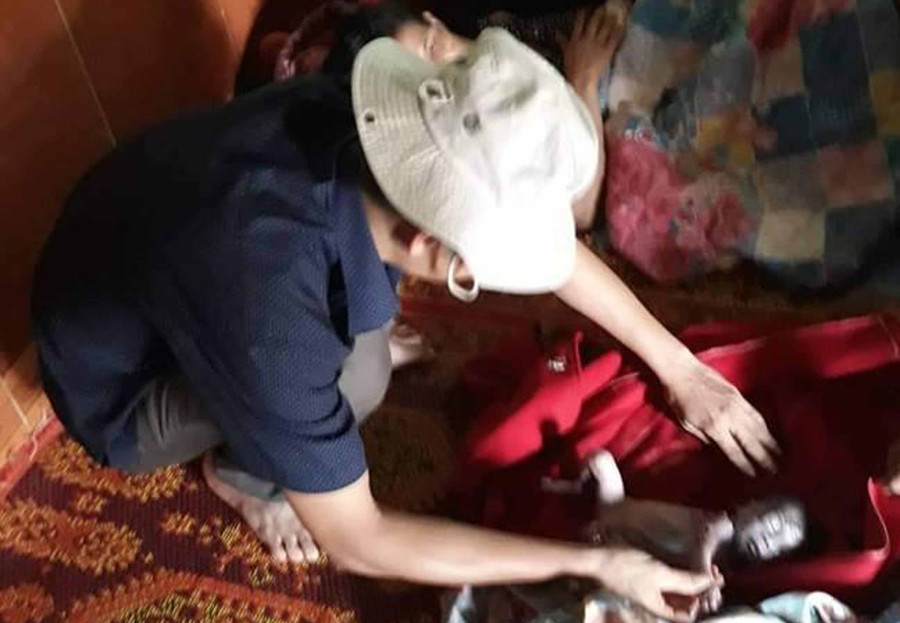 Anh Nguyễn Hùng Cường sơ cứu cho cháu bé. Ảnh: Lê Văn Châu