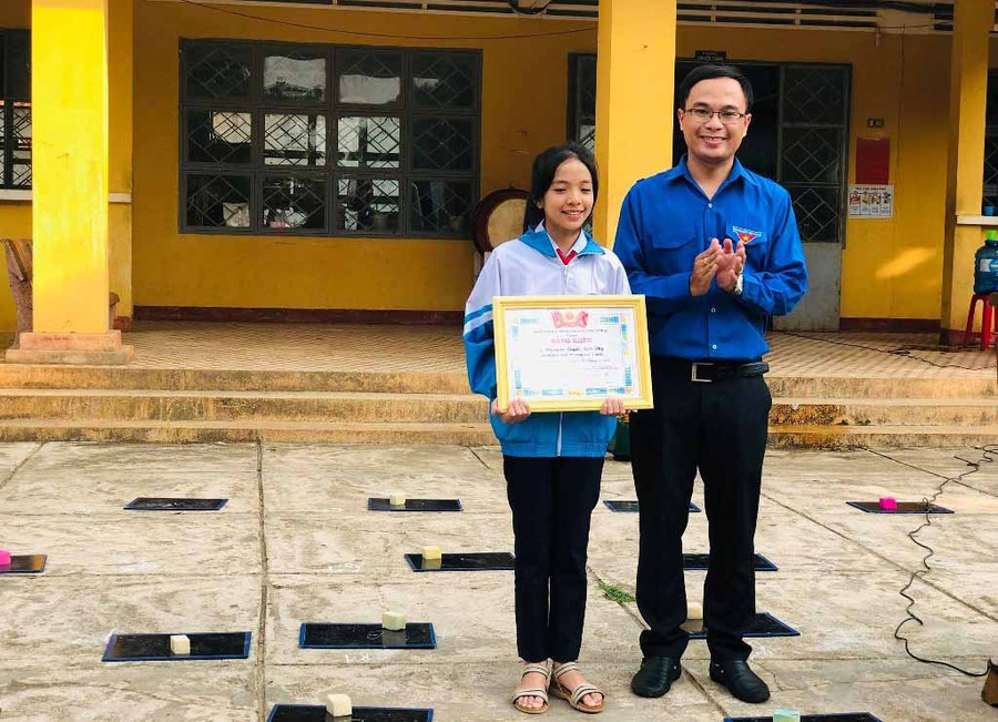 Anh Đỗ Đức Thanh-Uỷ viên Ban Thường vụ Tỉnh đoàn, Phó Chủ tịch Thường trực Hội đồng Đội tỉnh tặng Bằng khen cho em Nguyễn Tuyết Anh Thy. Ảnh: Phan Lài