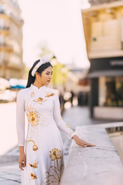 Không chỉ tôn nét thanh tân của người mặc, mẫu áo dài còn giữ được nét đẹp truyền thống thông qua phom dáng. Họa tiết mang gam vàng đồng giúp đem đến sự sang trọng, nổi bật cho tà áo. 