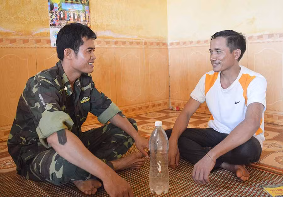  Trưởng thôn Rơ Lan Vân (bìa phải) trò chuyện với Bộ đội Biên phòng. Ảnh: A.H