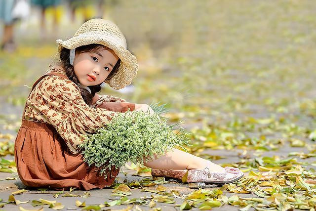  Cô bé Nguyễn Phạm Tú Anh 6 tuổi vui thích tạo dáng, đùa nghịch trên con đường ngập lá vàng giữa lòng Hà Nội.