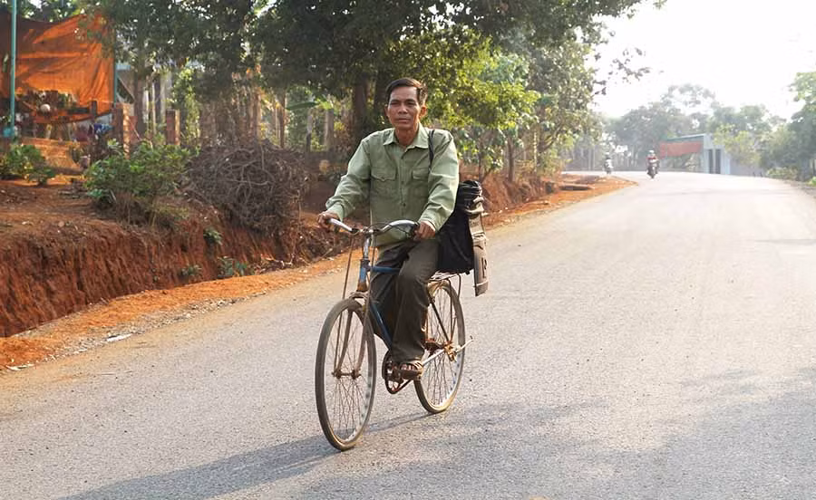  Hàng ngày, ông Rơ Châm Ngót vẫn rong ruổi trên chiếc xe đạp để chuyển thư từ. Ảnh: L.V.N 