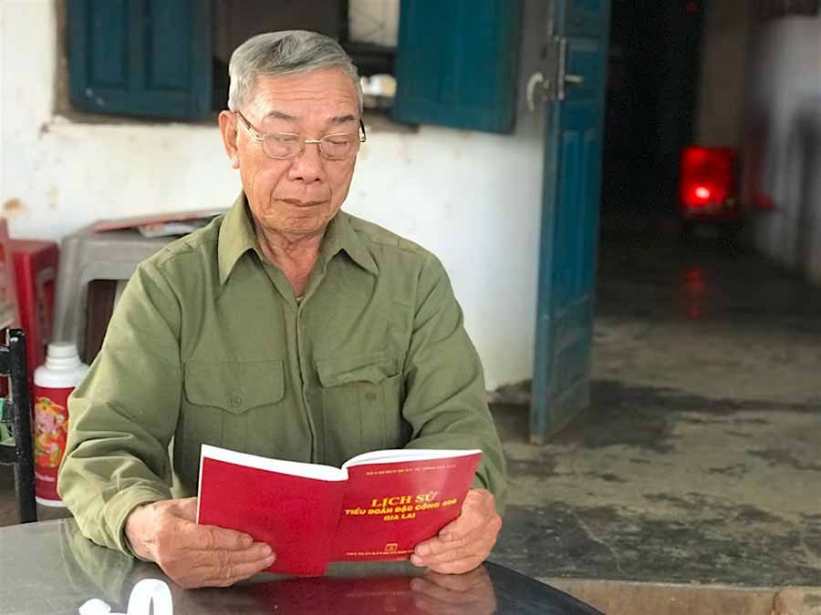 Cựu binh Dương Công Hoan tìm lại những kỷ niệm đấu tranh của đơn vị qua cuốn lịch sử Tiểu đoàn Đặc công 408. Ảnh: Mộc Trà