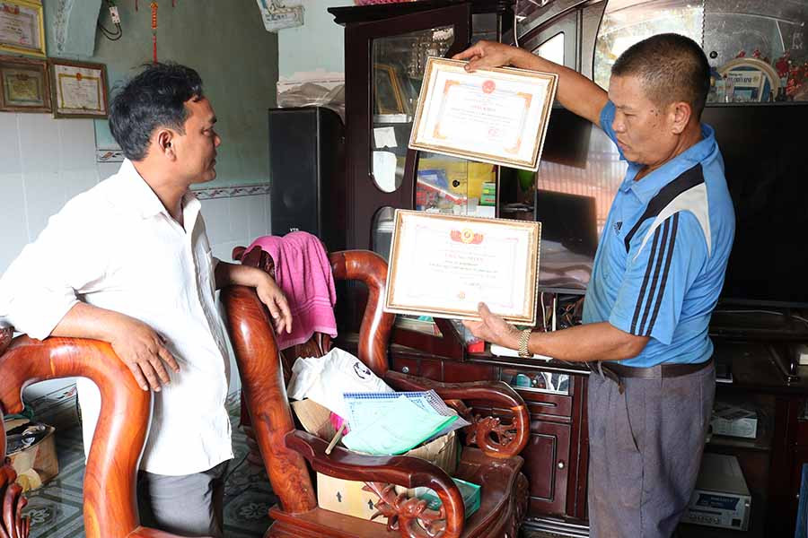 Ông Hụy cho xem những giấy khen về thành tích mà mình đạt được trong thời gian qua. Ảnh: N.S