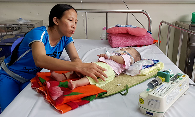  Chị Dung chăm sóc con gái bị viêm màng não tại Bệnh viện Nhi Trung ương. Ảnh: Lê Nga.