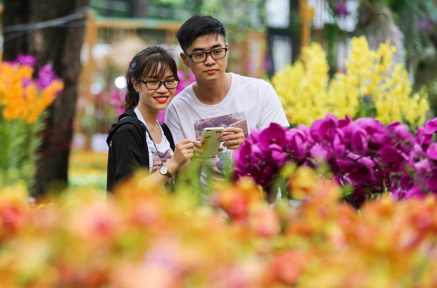 Đôi bạn trẻ dành ngày nghỉ lễ của mình dạo chơi hội hoa lan.