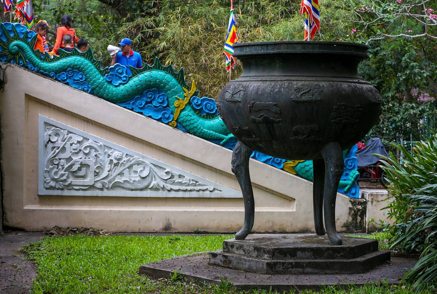 Hai bên lối vào đặt chiếc đỉnh mang phong cách cửu đỉnh nhà Nguyễn, có tuổi đời hơn 50 năm. Hai bên lối vào đặt chiếc đỉnh mang phong cách cửu đỉnh nhà Nguyễn, có tuổi đời hơn 50 năm.