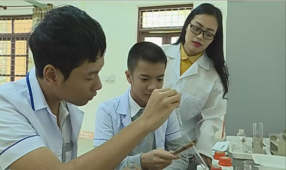 Công Thành, Lê Hoàn cùng cô giáo Mỹ Duyên (từ trái qua) trong phòng thí nghiệm của nhà trường - Ảnh: L.GIANG