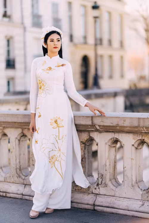  Ngọc Hân diện áo dài tại đất Pháp. Mẫu áo dài trắng mang họa tiết hoa sen sẽ giúp bạn để lại ấn tượng sâu đậm với người xung quanh bởi vẻ dịu dàng và yêu kiều. 
