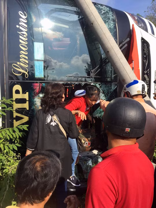 Người dân phải đập kính để giải cứu người bên trong xe trong khi xe bị lật nghiêng và bị cột điện gãy đè lên