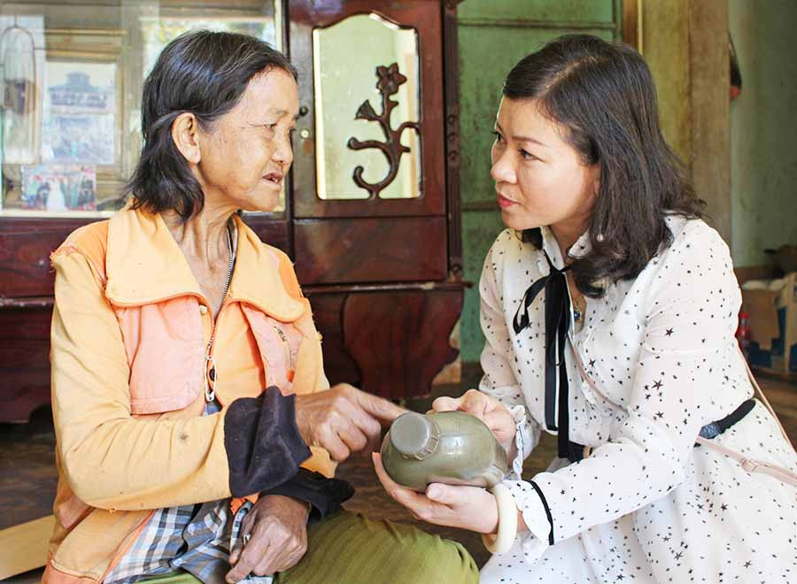 Bà Ksor Hmyui (bìa trái) kể những kỷ niệm về chồng-Anh hùng Rơ Châm Ớt . Ảnh: P.L