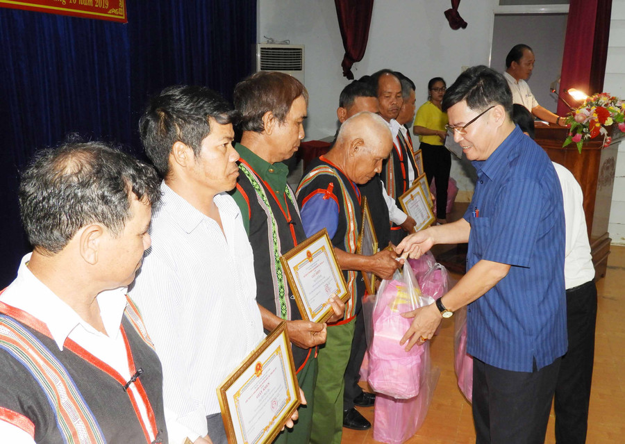 Lãnh đạo huyện Đức Cơ trao quà và giấy khen cho già làng, trưởng thôn và người uy tín tiêu biểu . Ảnh: Thanh Nhật