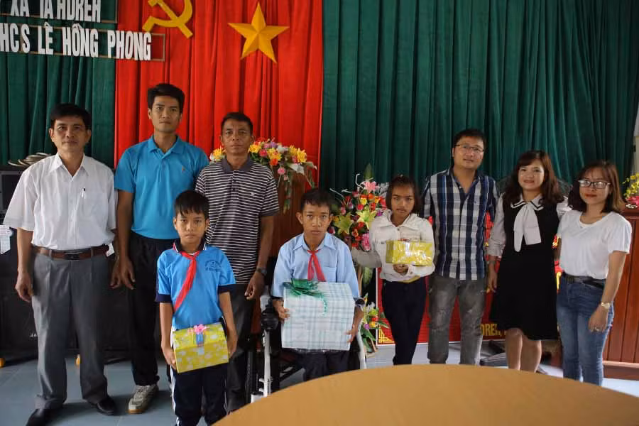  Em Nay Khuên (hàng trước, thứ 2 từ trái sang) cùng các bạn nhận quà của nhóm thiện nguyện Hoa Mặt Trời. Ảnh: M.H