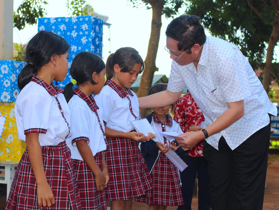 Ông Nguyễn Dũng-Giám đốc Sở Tài chính-trao học bổng cho các em học sinh nghèo. Ảnh: Hồng Thi