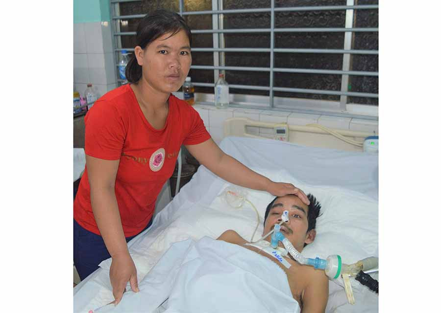 Chị Lam chăm sóc chồng tại bệnh viện. Ảnh: Đ.Y  Chị Lam chăm sóc chồng tại bệnh viện. Ảnh: Đ.Y