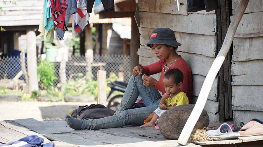 Chị Đinh HRach-vợ Đinh Uac-cùng con gái 19 tháng tuổi buồn bã bên hiên nhà sàn. Ảnh: L.V.N