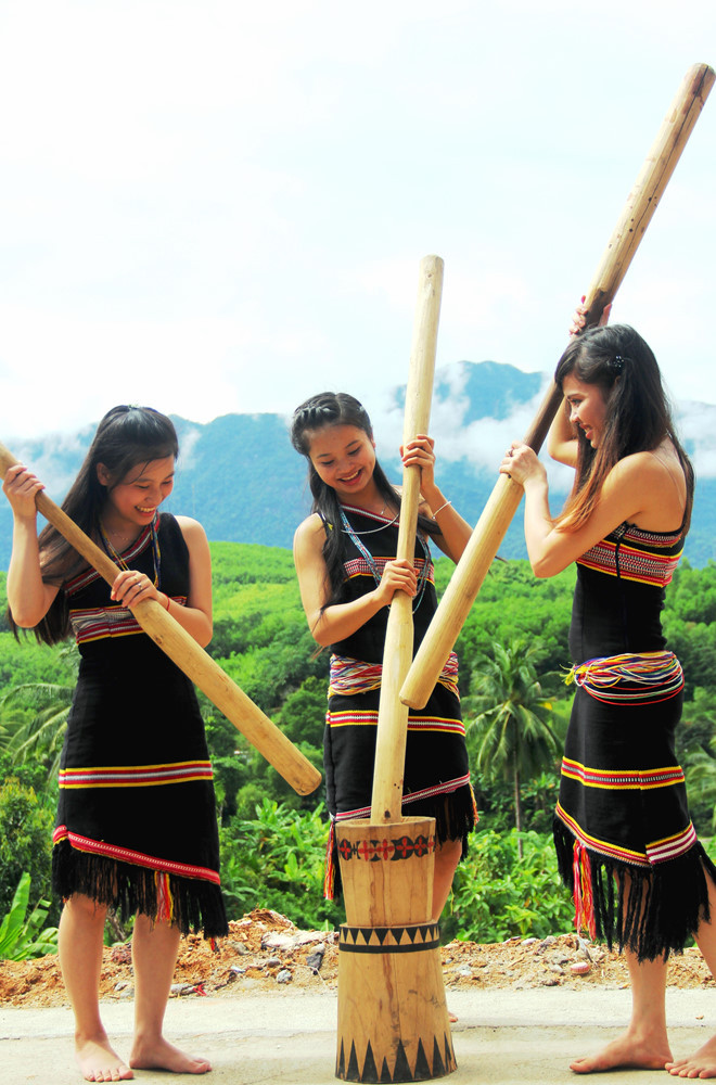 Những cô gái Cơ Tu với nụ cười duyên dáng đang giã gạo - ẢNH: MẠNH CƯỜNG