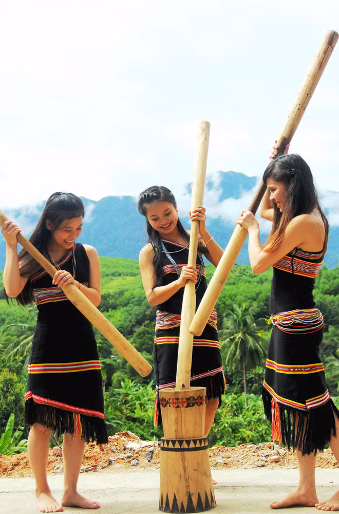 Những cô gái Cơ Tu với nụ cười duyên dáng đang giã gạo - ẢNH: MẠNH CƯỜNG