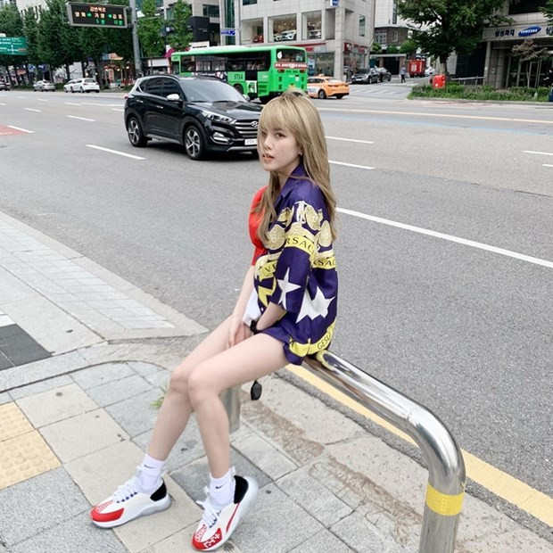  Thiều Bảo Trâm khoe chân thon và làn da trắng nõn nhờ diện sơmi Versace, mix cùng giày thể thao theo phong cách giấu quần.