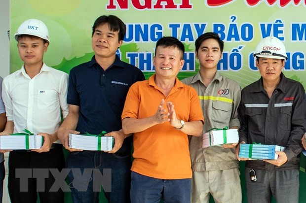 Anh Phạm Hồng Điệp (áo vàng, giữa) tặng quà động viên cán bộ công nhân viên Khu công nghiệp Nam Cầu Kiền tại chương trình Ngày đoàn viên chung tay bảo vệ môi trường, chống rác thải nhựa. (Nguồn: TTXVN phát)