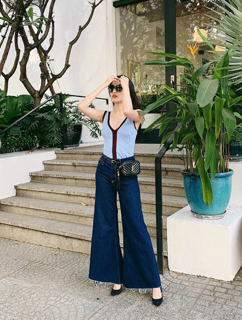 Huyền My không ngần ngại thay đổi phong cách với quần jeans ống loe thân rộng. Rõ ràng đây là kiểu quần khó tôn dáng nhưng nàng á hậu trông vẫn thanh lịch khi phối quần jeans cùng giày mũi nhọn, túi hiệu YSL và áo tank top cổ chữ V gợi cảm. Ảnh: @ngtran_huyenmy.