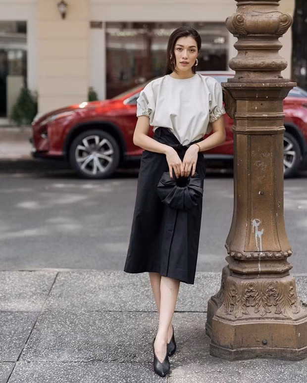  Diện áo blouse tay phồng nhẹ và chân váy tông màu đối lập, Lệ Hằng hoàn thiện phong cách nữ tính bằng đôi giày cắt chữ V cùng túi xách bán nguyệt xinh xắn.