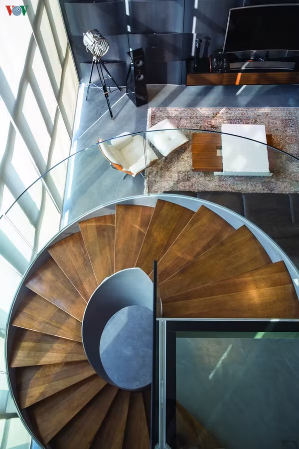 Góc nhìn ấn tượng từ trên cầu thang xoắn xuống khoảng thông tầng và phòng khách