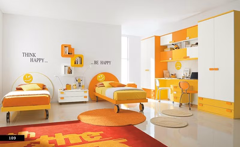 Hai chiếc giường đôi màu vàng cam với chân là những chiếc bánh xe tròn có thể giúp bạn di chuyển một cách dễ dàng. Chiếc tủ kéo dài, được thiết kế độc đáo, ở giữa là bàn học dành cho 2 trẻ nhỏ.