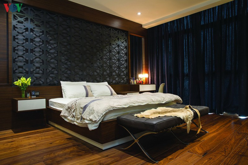 Phòng ngủ chính ở tầng trên được bố trí nội thất tiện nghi với điểm nhấn là mảng kim loại cắt hoa văn bằng laser phía đầu giường. Màu sắc nâu và xám gợi sự trầm ấm. Phòng ngủ chính ở tầng trên được bố trí nội thất tiện nghi với điểm nhấn là mảng kim loại cắt hoa văn bằng laser phía đầu giường. Màu sắc nâu và xám gợi sự trầm ấm.