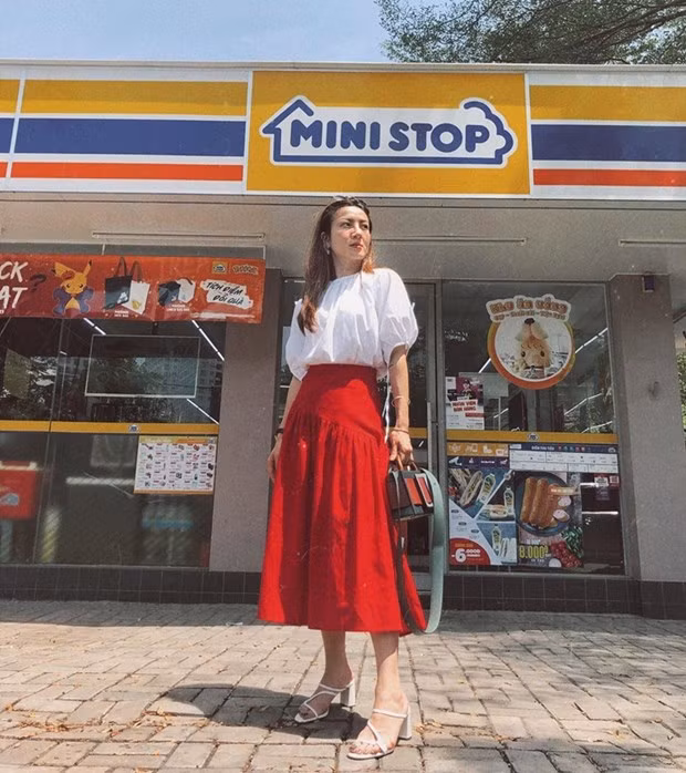 Áo blouse tay phồng trắng sáng được Yến Nhi phối cùng chân váy midi đỏ rực và sandal cao gót, tôn lên sắc vóc ngọt ngào.